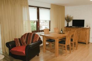 a living room with a table and chairs and a television at Ostsee-Apartment Wolgast in Wolgast