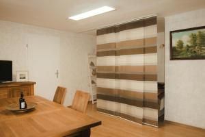 a dining room with a table and a striped wall at Ostsee-Apartment Wolgast in Wolgast