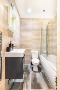 a bathroom with a sink and a toilet and a tub at Stylish Central Location Apartment in Norwich +16 photos