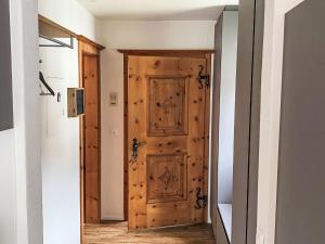 a wooden door in a room with a hallway at Apartment Wohnung Curtins by Interhome in Pontresina