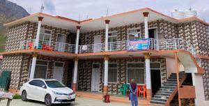 a white car parked in front of a building at Homeland Hotel and Resort in Burāwai