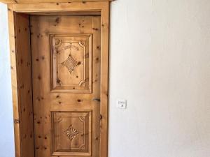 a wooden door in a room next to a wall at Apartment Wohnung Curtins by Interhome in Pontresina
