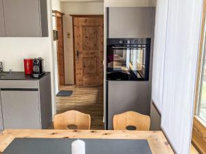 a kitchen with a table and a refrigerator at Apartment Wohnung Curtins by Interhome in Pontresina