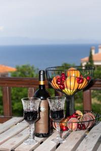 a bottle of wine and glasses on a wooden table at StefanoS Blue Horizon in Afitos +33 photos