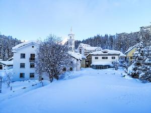 a town covered in snow with a building at Apartment 4 Bettwohnung by Interhome in Sils Maria