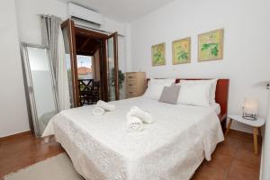 a bedroom with a white bed with towels on it at StefanoS Blue Horizon in Afitos