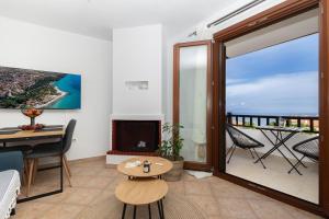a living room with a fireplace and a view of the ocean at StefanoS Blue Horizon in Afitos