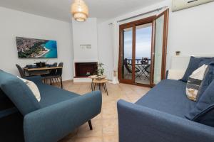 a living room with a couch and chairs and a television at StefanoS Blue Horizon in Afitos