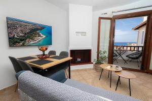 a living room with a couch and a table at StefanoS Blue Horizon in Afitos