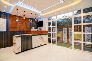 a lobby with a bar with a tv and windows at Hotel Aarnika Villa in New Town