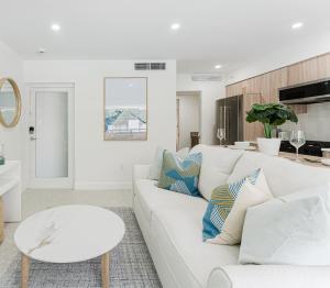 a white living room with a white couch and a table at The Mizner Pool Suite - Boca Beachside in Boca Raton