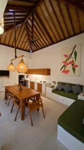 a living room with a wooden table and a kitchen at Golden Villa in Gili Trawangan