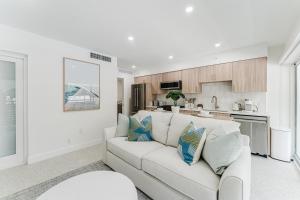 a white living room with a white couch and a kitchen at The Mizner Pool Suite - Boca Beachside in Boca Raton +32 photos