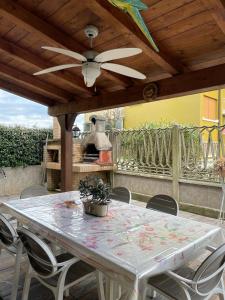 a table and chairs on a patio with a ceiling fan at Il sogno di Eda in Mozzate