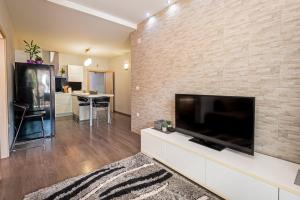 a living room with a large flat screen tv on a brick wall at Margaritum Blace - Seaview Apartment with Balcony in Blace +14 photos
