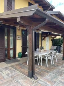a patio with a table and chairs under a roof at Il sogno di Eda in Mozzate