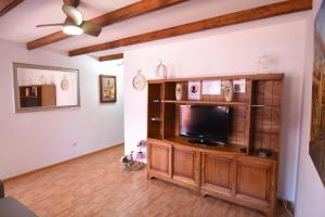 a living room with a flat screen tv on a wooden entertainment center at Villa Florymar a 12 minutos del aeropuerto in Ingenio