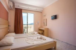 a bedroom with two beds and a window at Diagoras Hotel All Inclusive in Faliraki +123 photos
