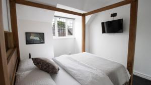 a bedroom with a bed and a tv on the wall at One-Bedroom flat in Cheam Village in Cheam