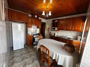 a kitchen with a table and a white refrigerator at Ron House in São Caetano