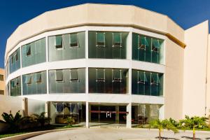 an office building with green windows and palm trees at Átrios Beach Hotel in Natal