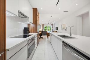 a kitchen with white counter tops and a sink at Cable Beach Condo Large private patio with BBQ in Nassau +28 photos