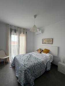 a bedroom with a bed with a blue blanket and a window at FoFo Apartamento 78 in Cijuela