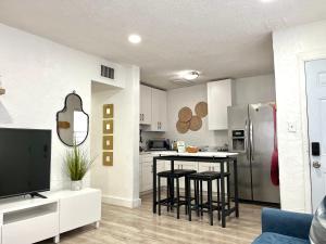 a kitchen with white cabinets and black stools in a room at Sanctuary Retreat Florida HardRock in Hollywood
