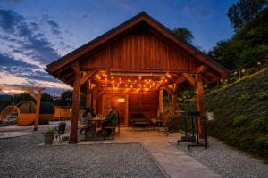 a wooden pavilion with lights and people sitting at a table at Brzegowy Relaks in Mszana Dolna