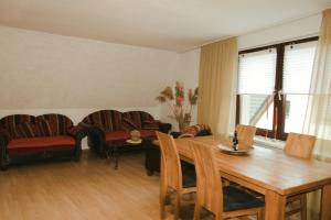 a living room with a wooden table and chairs at Ostsee-Apartment Wolgast in Wolgast +8 photos