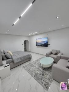 a living room with a couch and a table at شاليه روز حتا - Hatta Rose Chalet in Hatta