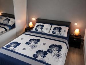 a bedroom with a bed with blue and white sheets and pillows at Les Logis de la Seugne in Saint-Germain-de-Lusignan