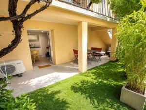 a backyard with a lawn and a house at Chez Aurel et Ju in Tournon-sur-Rhône +4 photos