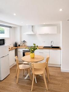 a kitchen with a wooden table and chairs in a kitchen at Chez Aurel et Ju in Tournon-sur-Rhône