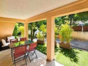 a patio with a table and chairs and a couch at Chez Aurel et Ju in Tournon-sur-Rhône