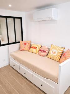 a bed in a room with pillows on it at Chez Aurel et Ju in Tournon-sur-Rhône