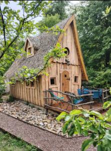 a small wooden house with a thatched roof at La chaumière ensorcelée in Anor