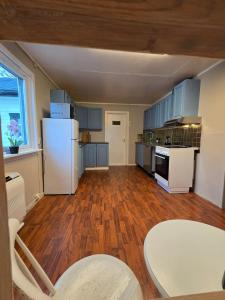 a kitchen with blue cabinets and a white refrigerator at Oldervik Sea House in Tromsø