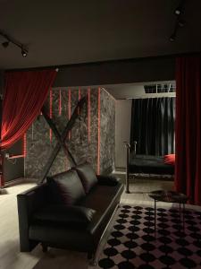 a living room with a couch and red curtains at The secret room in Alba Iulia