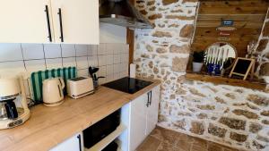 a kitchen with a counter and a stone wall at Maison rénovée, centre médiéval de Belvès in Belvès