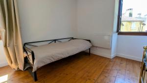 a small bed in a room with a window at Maison rénovée, centre médiéval de Belvès in Belvès