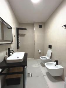 a bathroom with two sinks and a toilet in it at Sunshine Apt Qerret-Golem Beach-Self-Check-in in Golem +52 photos