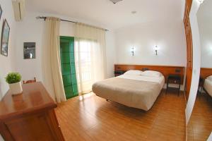 a bedroom with a bed and a wooden floor at Apartamentos La Palmera in Frontera