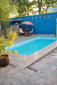 a swimming pool with a table and an umbrella at Casa Carol Vans in Peruíbe