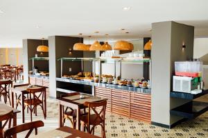 a restaurant with tables and chairs and a counter with food at Átrios Beach Hotel in Natal