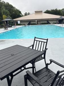 a picnic table and bench next to a swimming pool at Epworth By The Sea in Saint Simons Island +23 photos