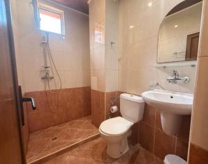 a bathroom with a toilet and a sink and a shower at Guest House Georgieva Ravda in Ravda
