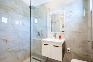 a bathroom with a shower and a sink and a mirror at Hotel Fabio in Ksamil +81 photos