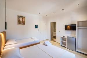 a white room with a bed and a kitchen at Hotel Fabio in Ksamil