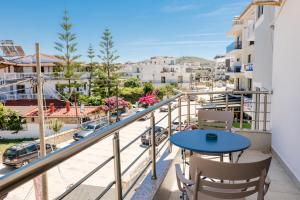 a balcony with a blue table and chairs and a city at Hotel Fabio in Ksamil
